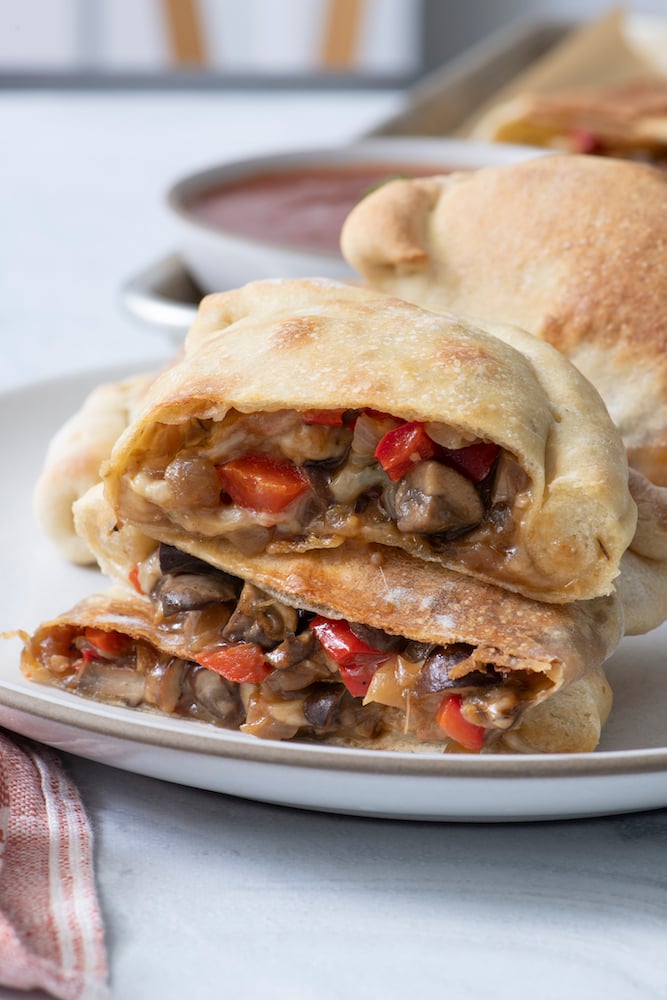 Stacked calzones on a plate.